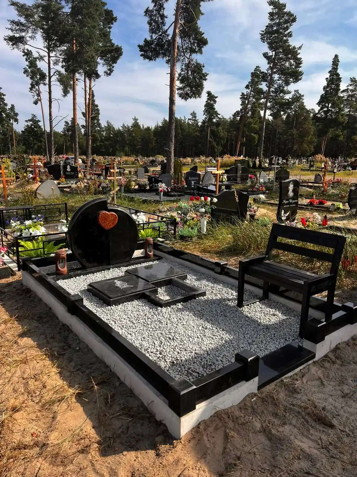 pabeigta kapavieta ar granīta perimetru un dekoratīvo šķembu segumu