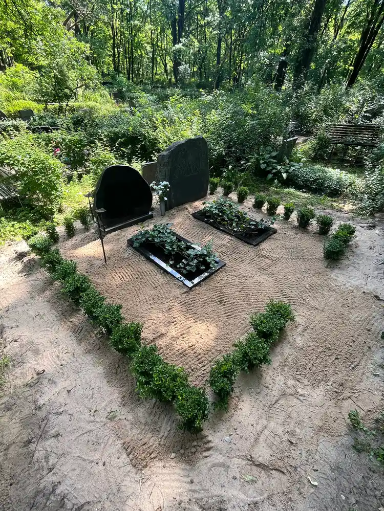 pabeigta kapavieta ar bukšu dzīvžogu un granīta apmalēm